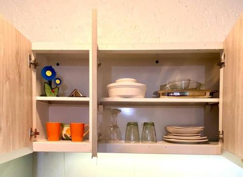 a kitchen cupboard with plates and dishes in it at Duplex con terraza y estacionamiento p auto! in Mendoza