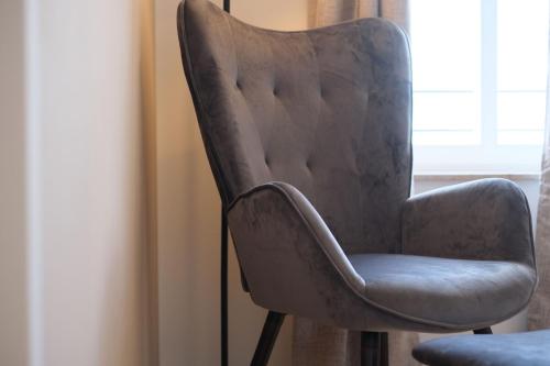 a gray chair sitting next to a window at See ums Eck Moderne Fewo am Hainer See in Neukieritzsch