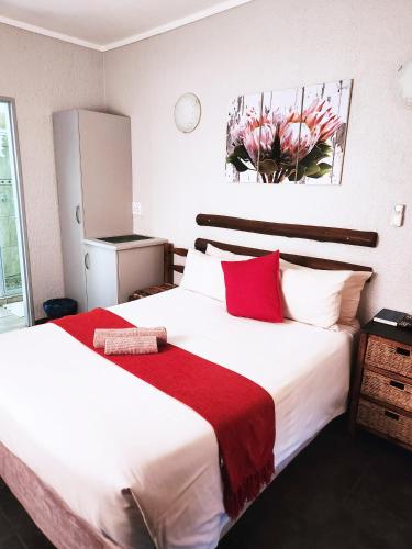 a hotel room with two beds with red pillows at Tramonto Lodge in Upington