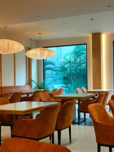 an empty restaurant with tables and chairs and an aquarium at 37th Crescent Hotel Bengaluru in Bengaluru
