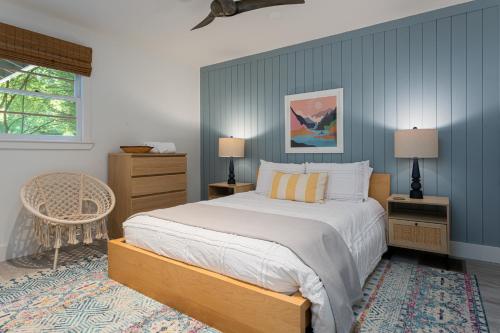 a bedroom with a bed and a blue wall at Blue Moon Cottage in Lake Lure