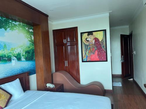 a bedroom with a bed and a painting on the wall at Thành Vinh Hotel & Apartment in Ho Chi Minh City