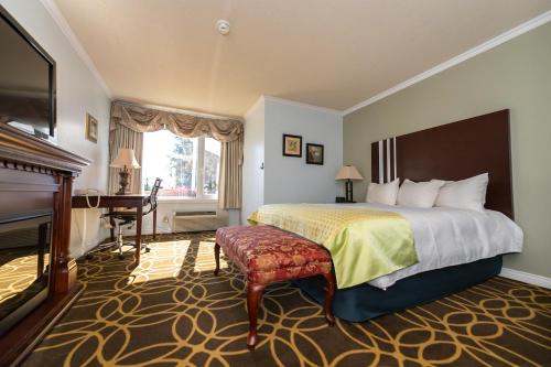 a hotel room with a bed and a piano at Auberge Gisele's Inn in Baddeck