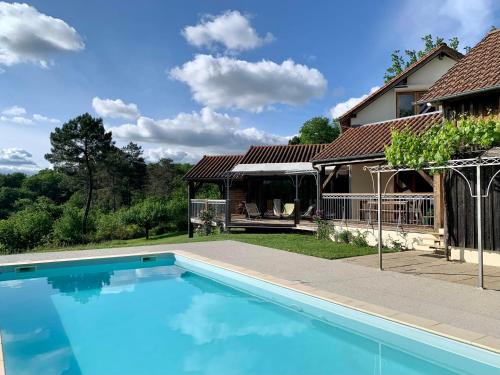une piscine devant une maison dans l'établissement La Maison des Oiseaux, à Peyzac-le-Moustier