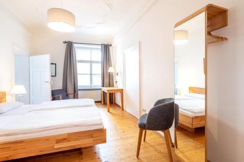 1 dormitorio con cama, silla y espejo en Goldenes Schiff, en Passau