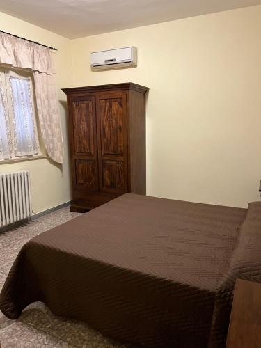 a bedroom with a bed and a wooden cabinet at Il Miravalle Ristorante & Camere in Manciano