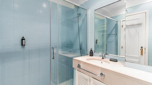 Un baño con ducha, lavabo y espejo. en LovelyStay - Porto Beach Apartment, en Oporto
