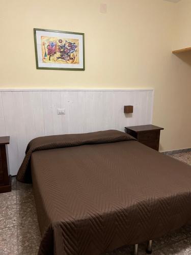 曼恰諾的住宿－Il Miravalle Ristorante & Camere，卧室配有一张床,墙上挂着一幅画
