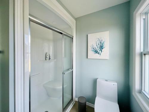 a bathroom with a glass shower and a toilet at Lucky Bay Hideaway - Seaview Sauna & cedar hot tub in Campbellton