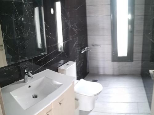 a bathroom with a white sink and a toilet at villa kate view in Ratzaklíon