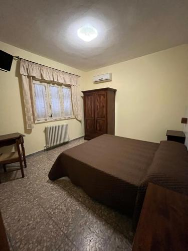 a bedroom with a large bed and a window at Il Miravalle Ristorante & Camere in Manciano