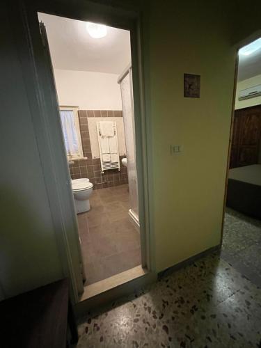 a bathroom with a toilet and a door to a room at Il Miravalle Ristorante & Camere in Manciano
