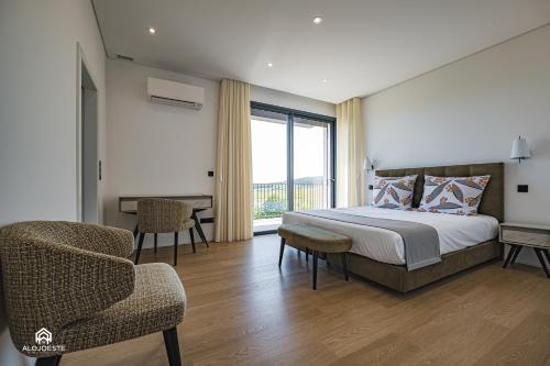 ein Schlafzimmer mit einem Bett, einem Stuhl und einem Fenster in der Unterkunft Quinta da Estima in Dous Portos