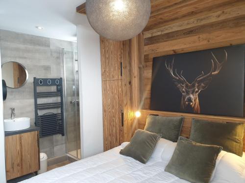 Dormitorio con cama con ciervo en la pared en les etoiles de la plagne le quartz, en Belle Plagne