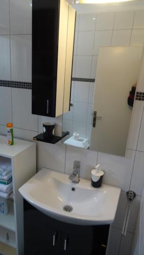 a bathroom with a white sink and a mirror at Nikiva I in Ćuprija