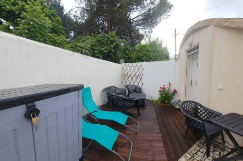 a patio with chairs and tables and a white fence at La Maison des Schtroumpfs in Pau