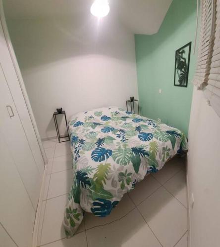 uma cama com um edredão florido num quarto em La Maison des Schtroumpfs em Pau