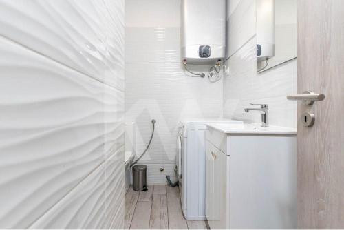 a white bathroom with a sink and a toilet at CASA DOS ARCOS in Coimbra