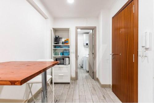 a kitchen with a wooden table and a microwave at CASA DOS ARCOS in Coimbra