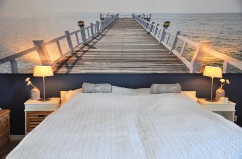 a bedroom with a bed and a wooden pier at Ort Lemkenhafen Ostseeperle in Fehmarn