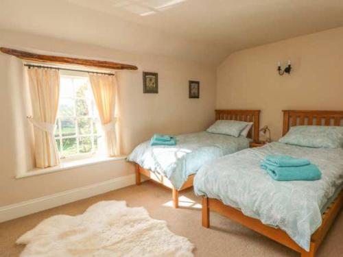 a bedroom with two beds and a window at Beautiful 3-Bed House in Longnor near Buxton in Longnor