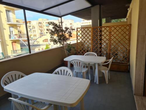 two tables and chairs on a balcony with a view at Monti Guest House Alghero in Alghero