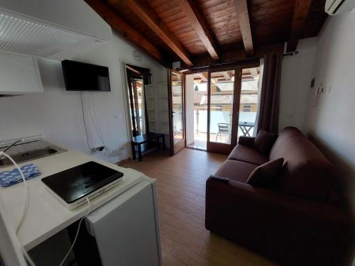 a kitchen and living room with a couch and a counter at Pizzocolo resort fasano in Gardone Riviera