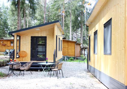 a small yellow house with a table and chairs at Camping la Pineta in Santa Maria Maggiore