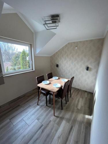 a dining room with a table and chairs and a window at Vila Boska Palic in Palić