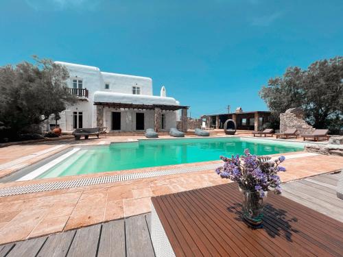 una piscina con un jarrón de flores en una terraza de madera en Dreamy Boho 5bed Villa with Pool and Ocean View en Mykonos ciudad