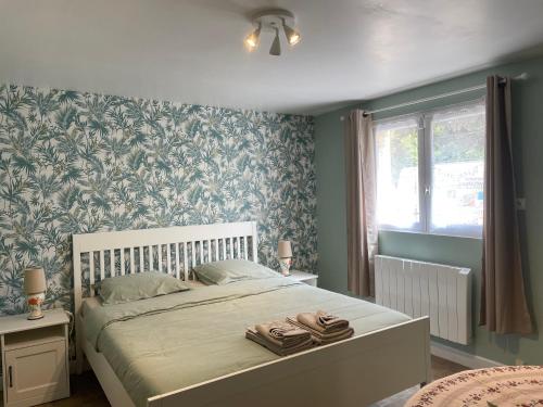 um quarto com uma cama grande e papel de parede azul e verde em Chambre indépendante em Lalinde