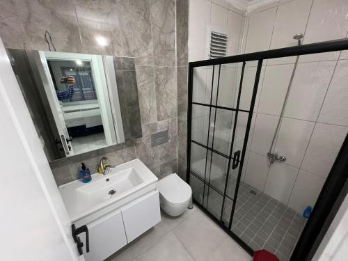 uma casa de banho com um WC, um lavatório e um chuveiro em LOYA APARTMENTs em Trabzon