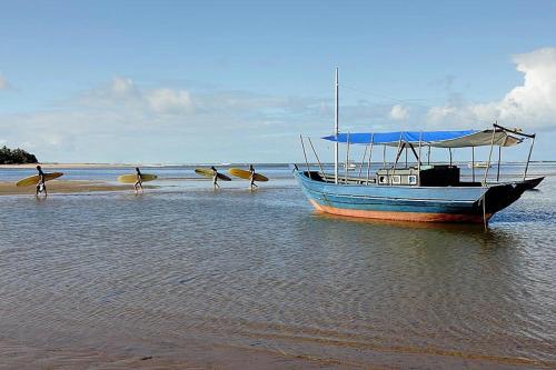 a boat sitting in the water on the beach at Barracuda Boutique in Itacaré