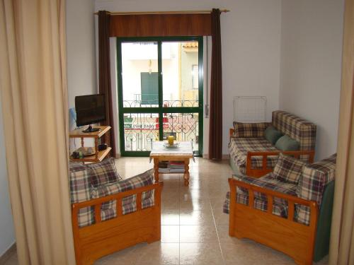 uma sala de estar com 2 sofás e uma varanda em GP Guest House em Alvor