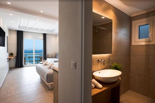 a bathroom with a sink and a bedroom with a bed at Magic View Suites Mykonos in M&yacute;konos City
