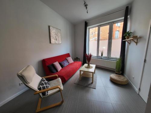 salon z czerwoną kanapą i oknem w obiekcie House of Mima w Brukseli