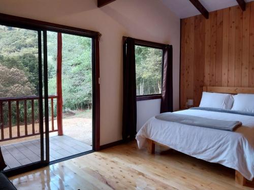CopeyにあるCuruba Lodgeのベッドルーム1室(ベッド1台付)、スライド式ガラスドアが備わります。