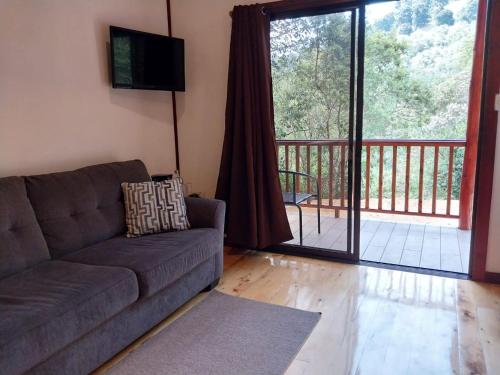 a living room with a couch and a balcony at Curuba Lodge in El Copey