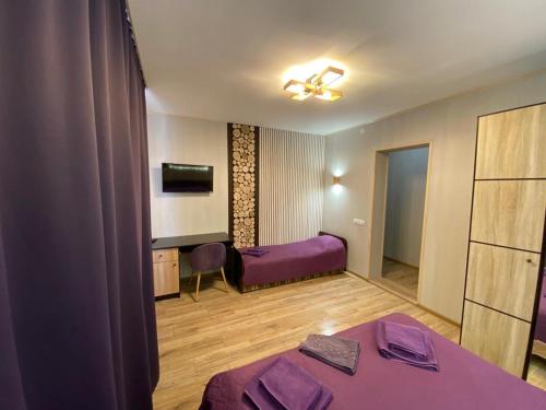 a room with a purple bed and a tv at Кукулька міні-готель in Slavske