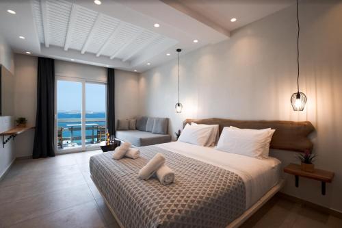 a bedroom with a bed with a view of the ocean at Magic View Suites Mykonos in Mýkonos City