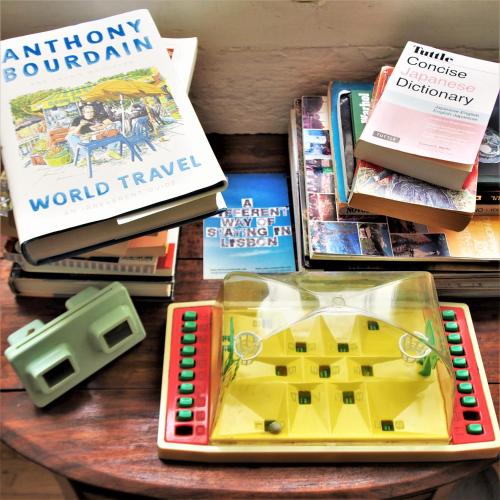 a table topped with books and a tray with a toy house at Living Lounge Hostel in Lisbon