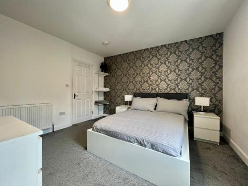 a bedroom with a white bed and two night stands at Oxford Street Stays in Southampton