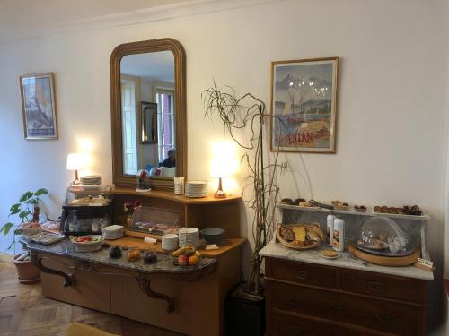 een kamer met een kaptafel met een spiegel en een dressoir bij Hôtel Continental in Évian-les-Bains