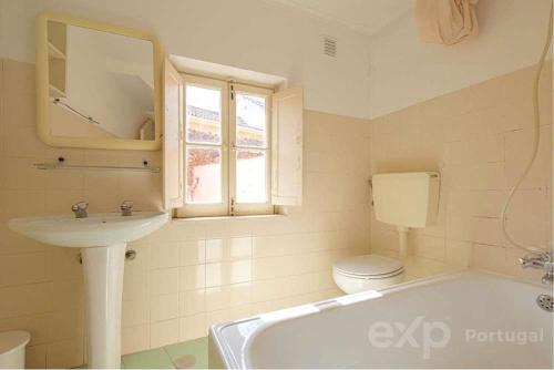 a bathroom with a tub and a sink and a toilet at Casa do Castelo in Lisbon