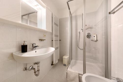 a white bathroom with a sink and a shower at Moar im Rumsein - Apt Saltenblick in Terlano