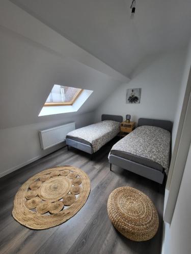 a attic room with two beds and a rug at House of Mima in Brussels