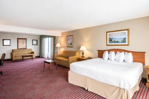 a hotel room with a large bed and chairs at Quality Inn Lakeland North in Lakeland