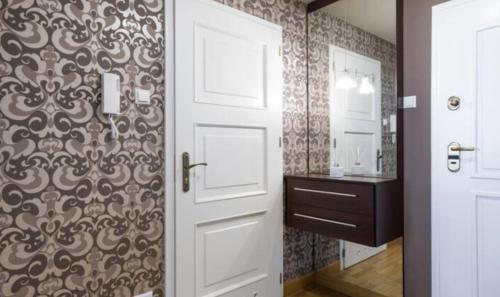 uma casa de banho com uma porta branca e um lavatório em Royal Parkside na Cracóvia