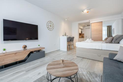 a white bedroom with a large bed and a table at Luni Apartment in Dubrovnik center in Dubrovnik