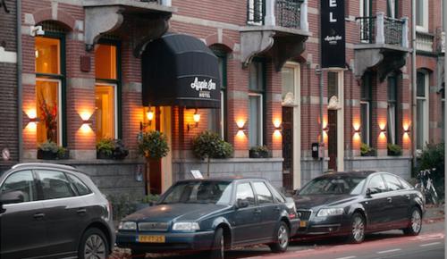 three cars parked in front of a building at Apple Inn Hotel in Amsterdam